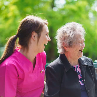 caregiver and senior laughing outdoors together