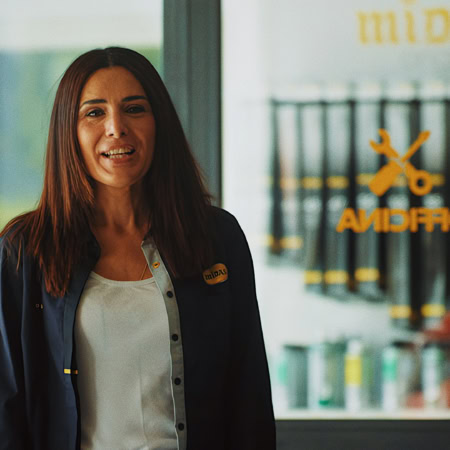 addetta midas sorridente nel negozio di ricambi auto