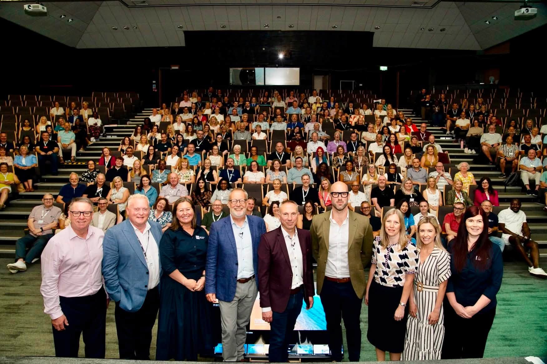 conference speakers and audience in modern auditorium