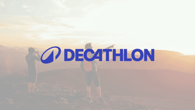 logo decathlon na górach przy zachodzie słońca