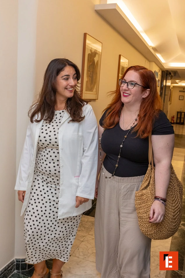 doctora y colega sonriendo en el pasillo