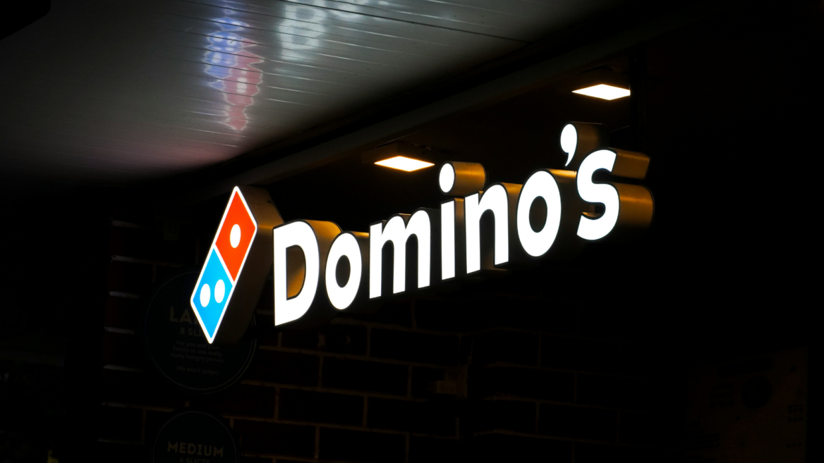dominos backlit storefront sign at night