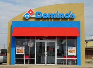 fachada dominos: pizzería con logo azul y rojo
