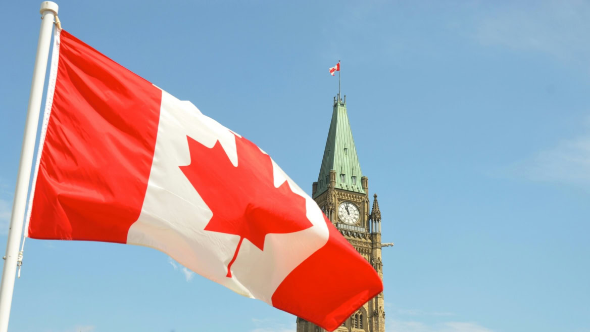 drapeau canadien flottant devant la tour dhorloge gothique