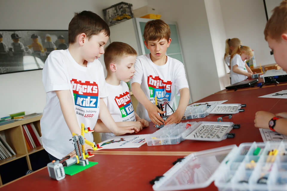 dzieci budują roboty z klocków lego na warsztatach