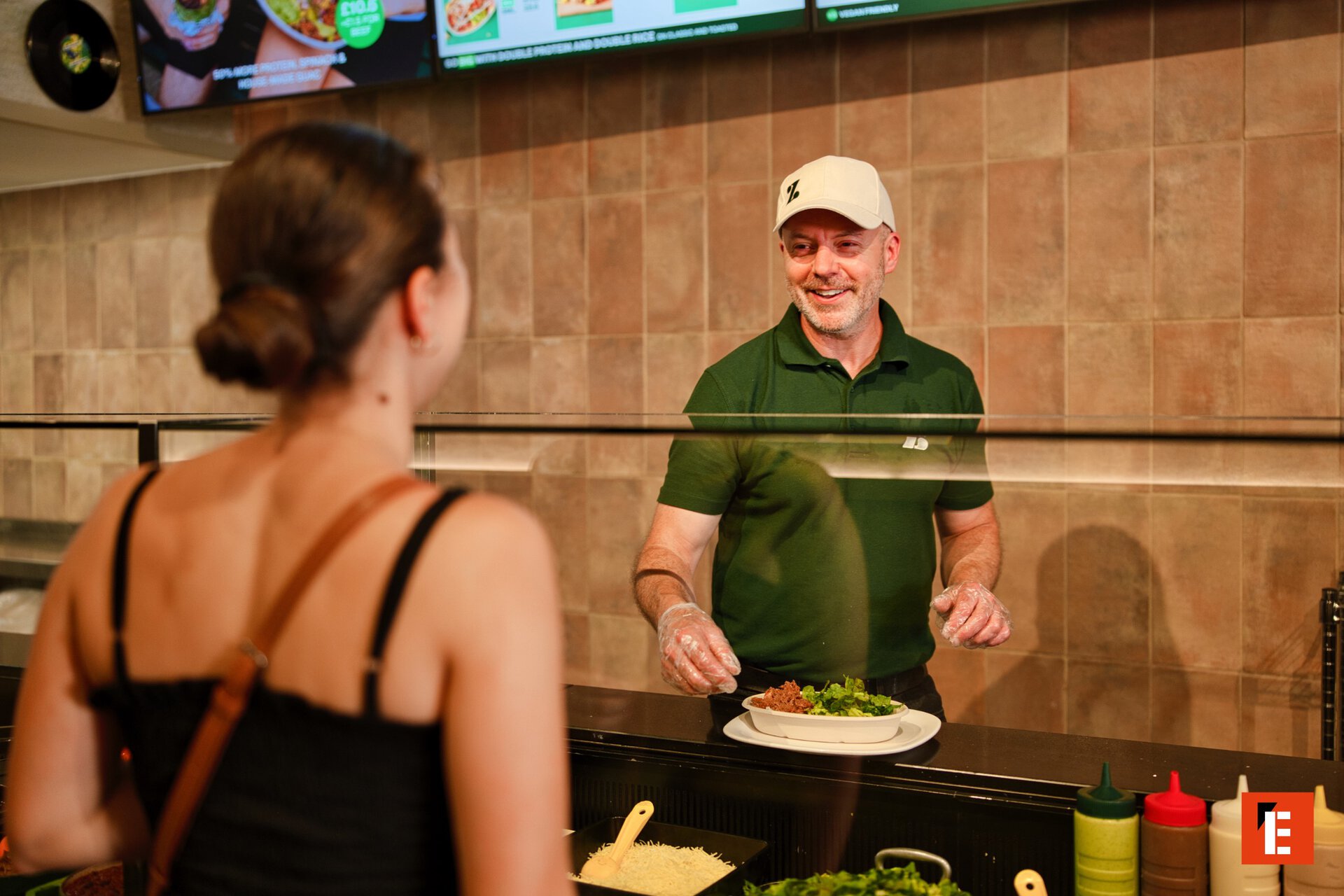 smiling server serving fresh bowl at counter