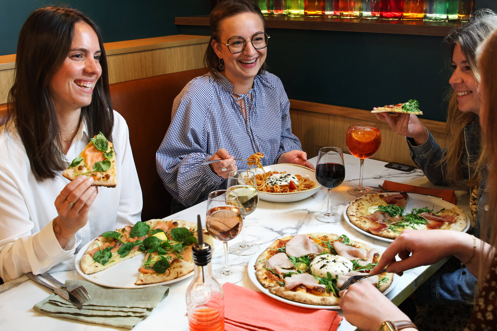 femmes en dîner convivial avec pizzas et vins