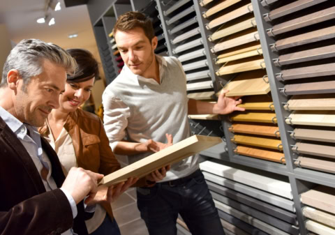 customers comparing wood flooring samples in showroom