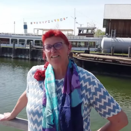 rothaarige frau lächelt am sonnigen hafensteg
