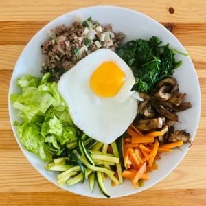 bunte frühstücksbowl mit spiegelei, gemüse und hackfleisch