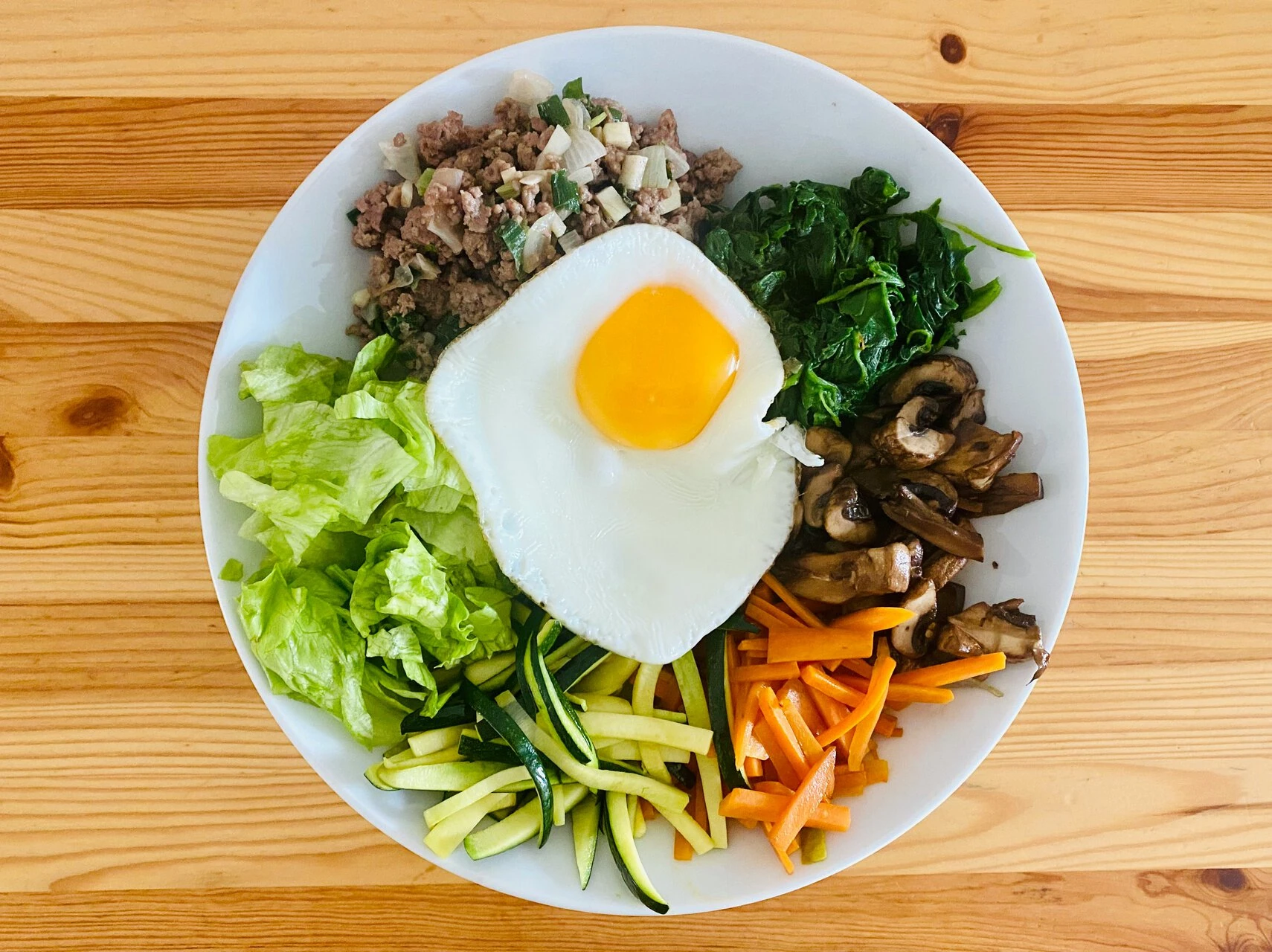bunte frühstücksbowl mit spiegelei, gemüse und hackfleisch