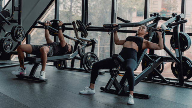 paired chest press workout in sunlit gym