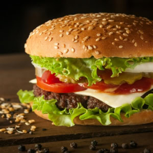 hamburger classique juteux au fromage, tomate et sésame