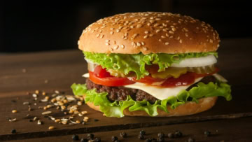 hamburger classique juteux au fromage, tomate et sésame