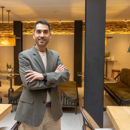 hombre sonriente en café coworking acogedor