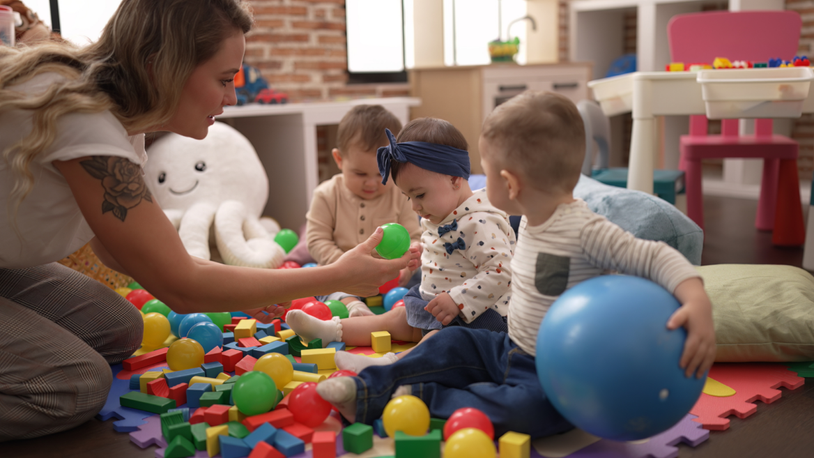 caregiver and toddlers playing in colorful daycare playroom