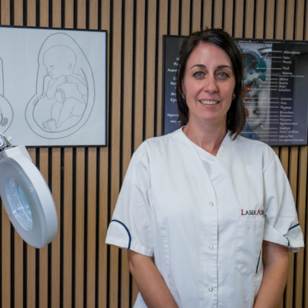 infirmière en cabinet avec lampe et schémas anatomiques