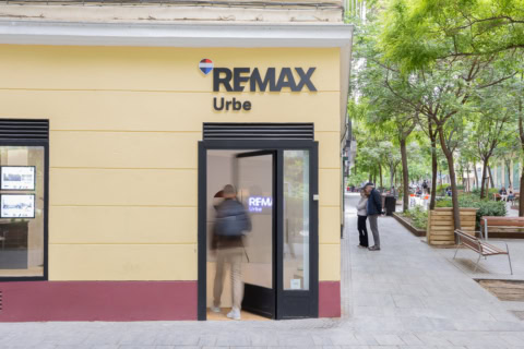 oficina remax con puerta abierta en calle arbolada