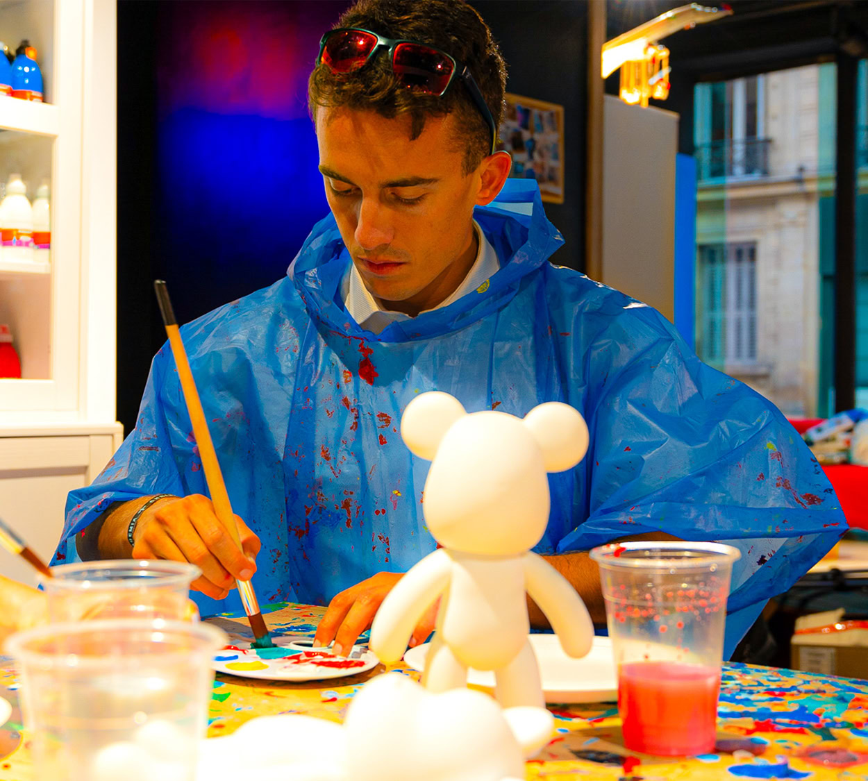 jeune artiste peint une figurine en atelier