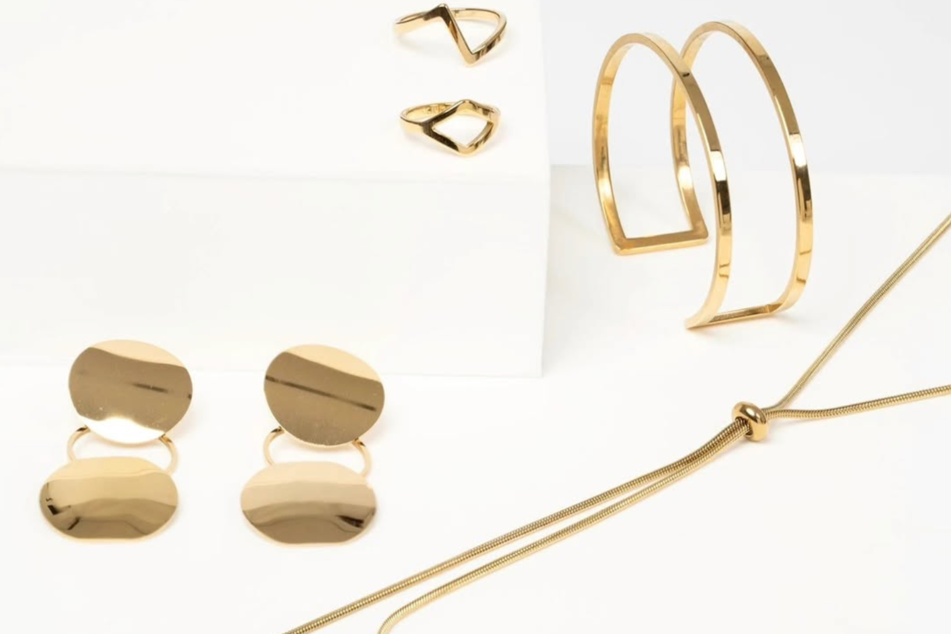 joyas doradas minimalistas: pendientes, anillos y brazalete