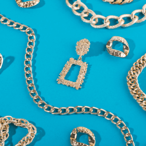 joyas de oro: cadenas, aros y colgantes sobre turquesa