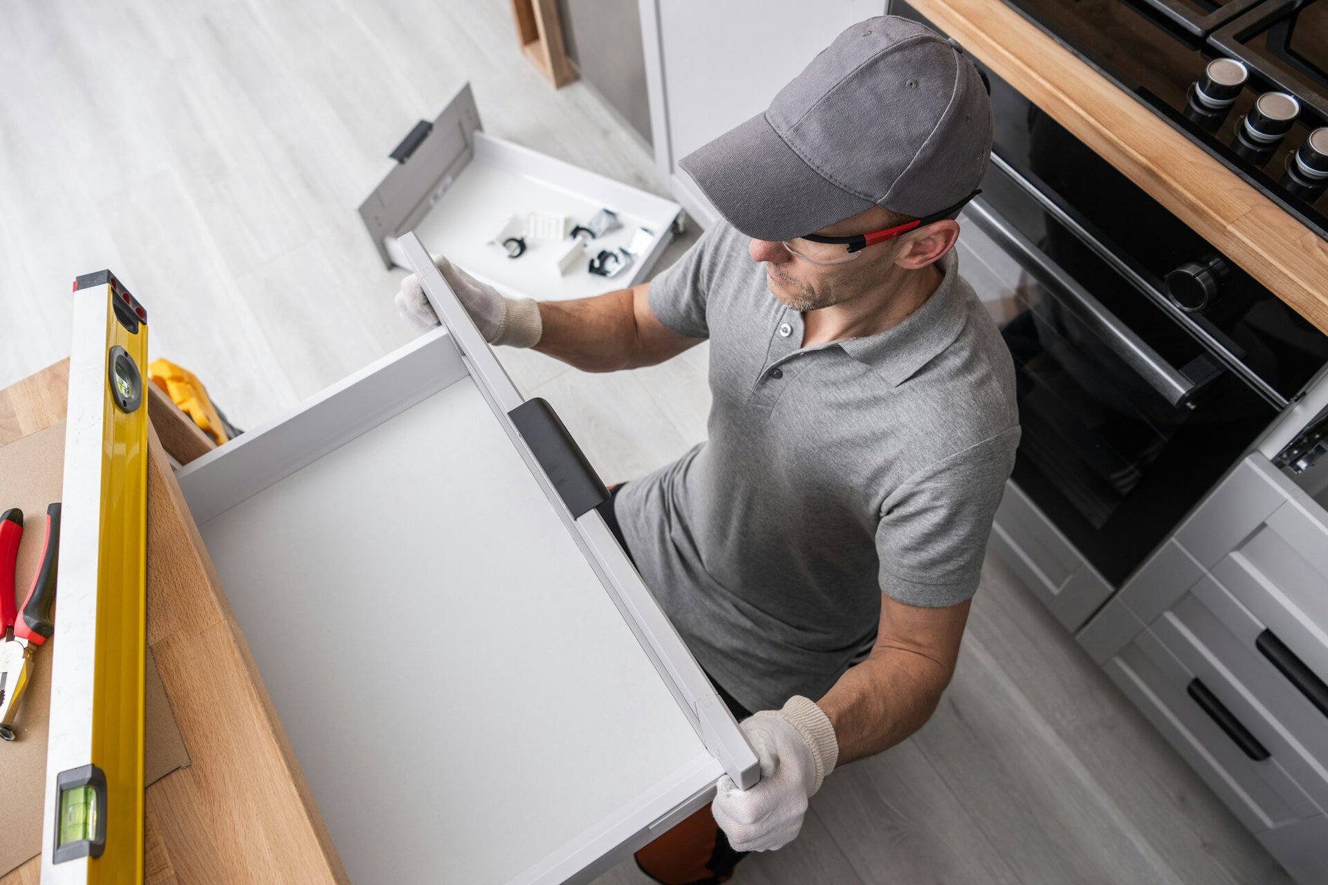 tradesman installing drawer in modern kitchen