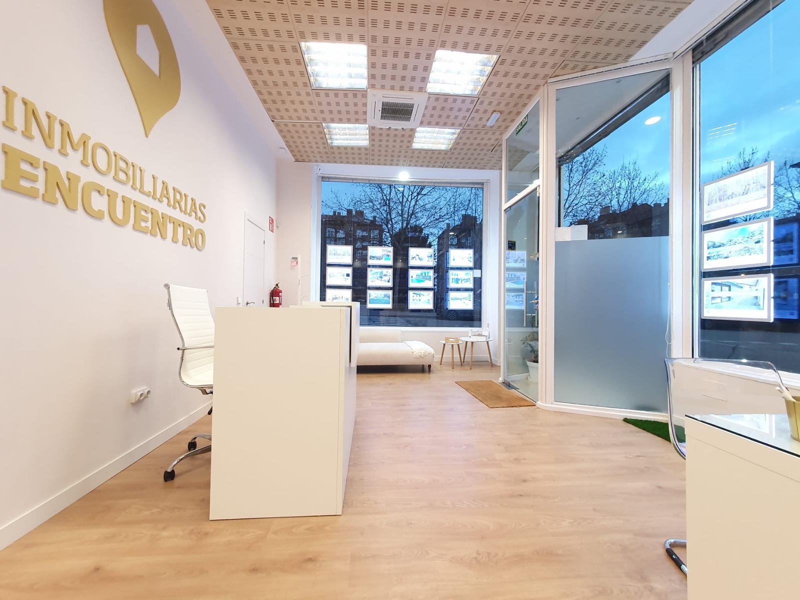 oficina inmobiliaria moderna con recepción y escaparate iluminado