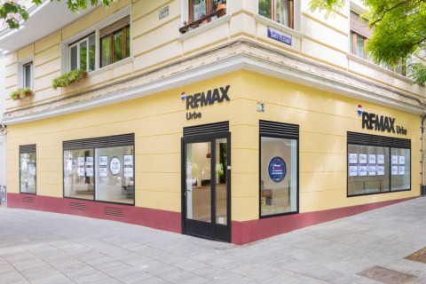 oficina re/max en esquina con escaparates inmobiliarios