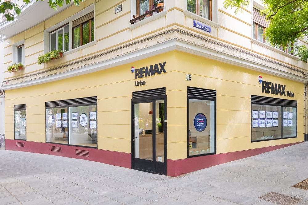 oficina re/max en esquina con escaparates inmobiliarios
