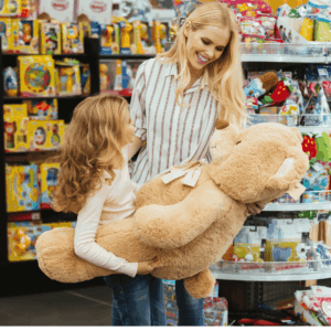 madre e hija con oso de peluche gigante en tienda