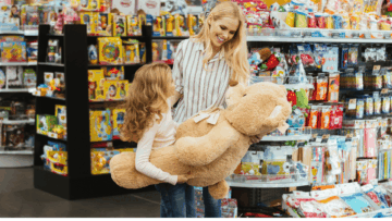madre e hija con oso de peluche gigante en tienda
