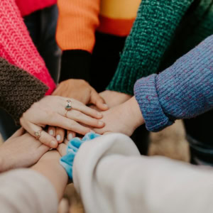 mains entrelacées : solidarité en pulls colorés