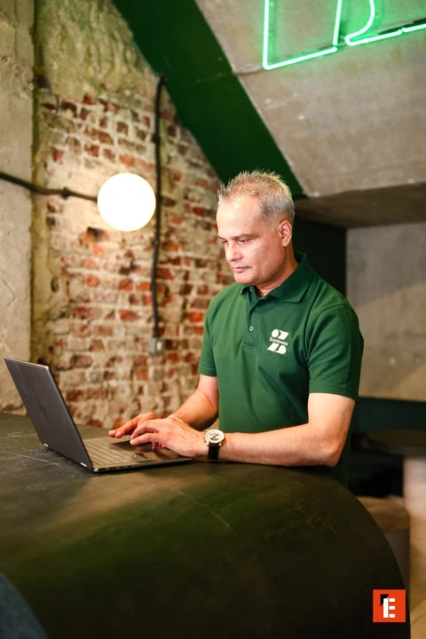 man working on laptop at industrial café counter