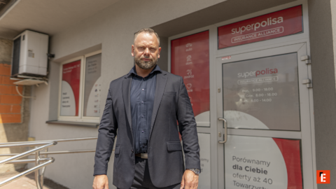 mężczyzna w garniturze przed biurem superpolisa