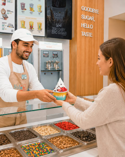 yogur helado y coberturas: cliente recibe vaso