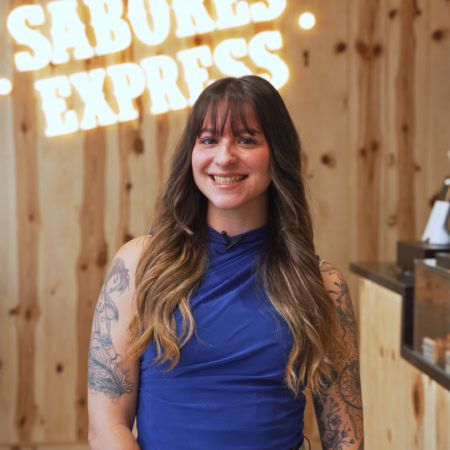 mujer tatuada sonriente en panadería sabores express