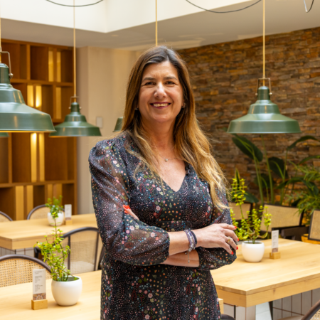 mujer sonriente en café coworking con vestido floral