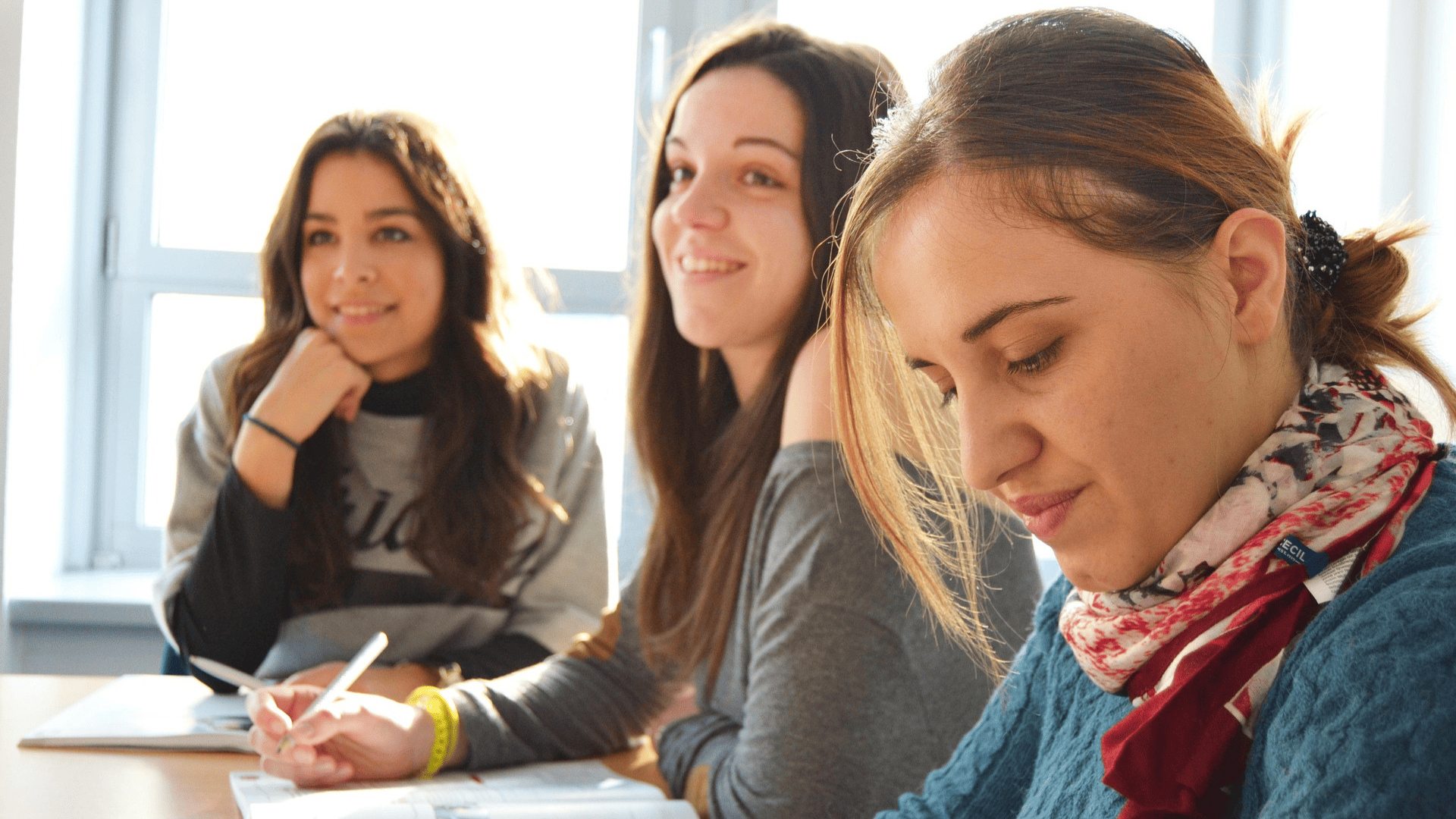 mujeres estudiando con luz natural y cuadernos