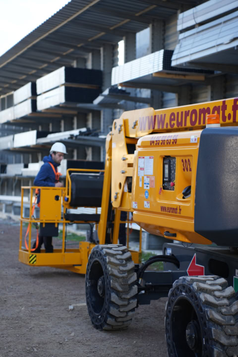 nacelle Élévatrice jaune sur chantier avec opérateur casqué