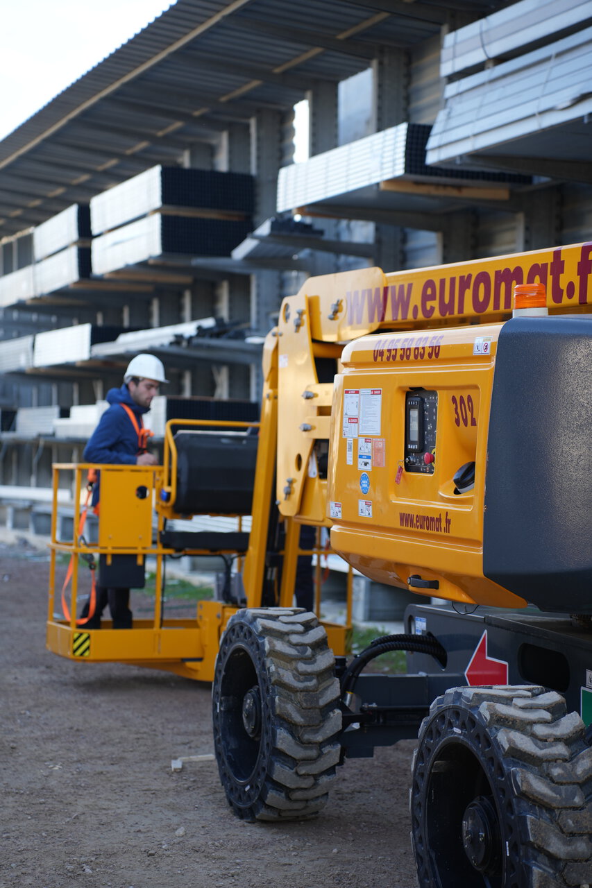 nacelle Élévatrice jaune sur chantier avec opérateur casqué