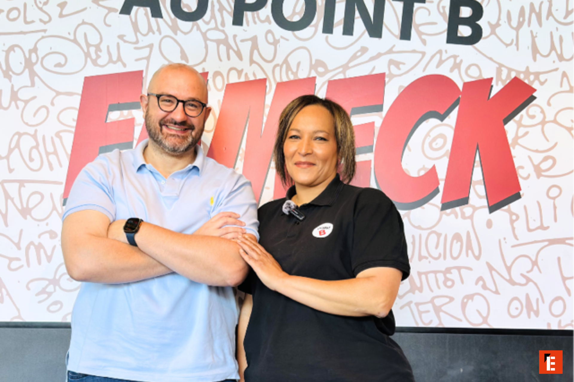 duo dÉquipe souriant devant marque rouge