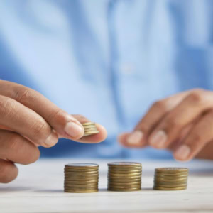 Épargne et budget : mains empilent des pièces