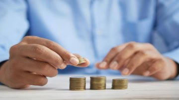 Épargne et budget : mains empilent des pièces