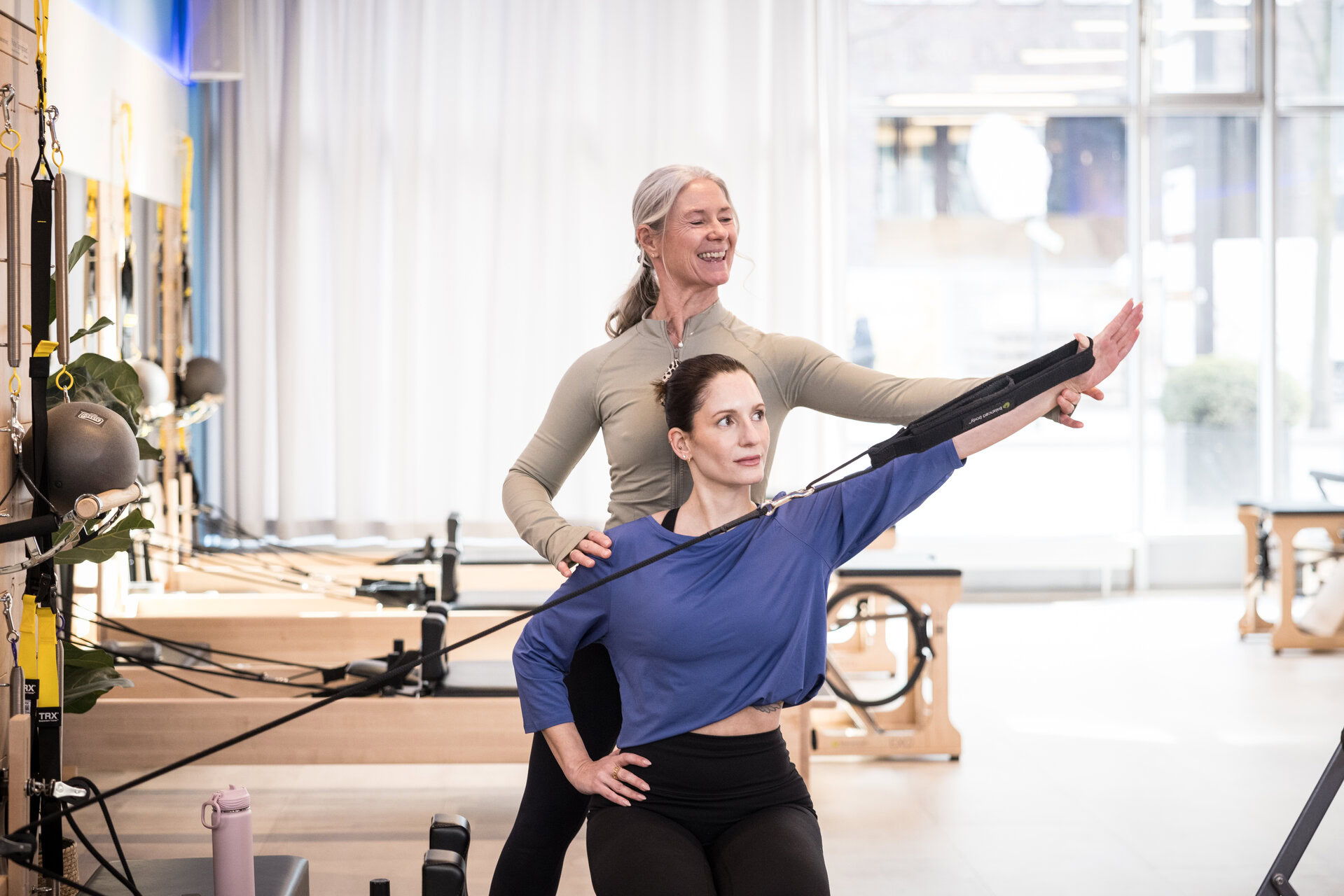 pilates reformer: trainerin korrigiert kundin
