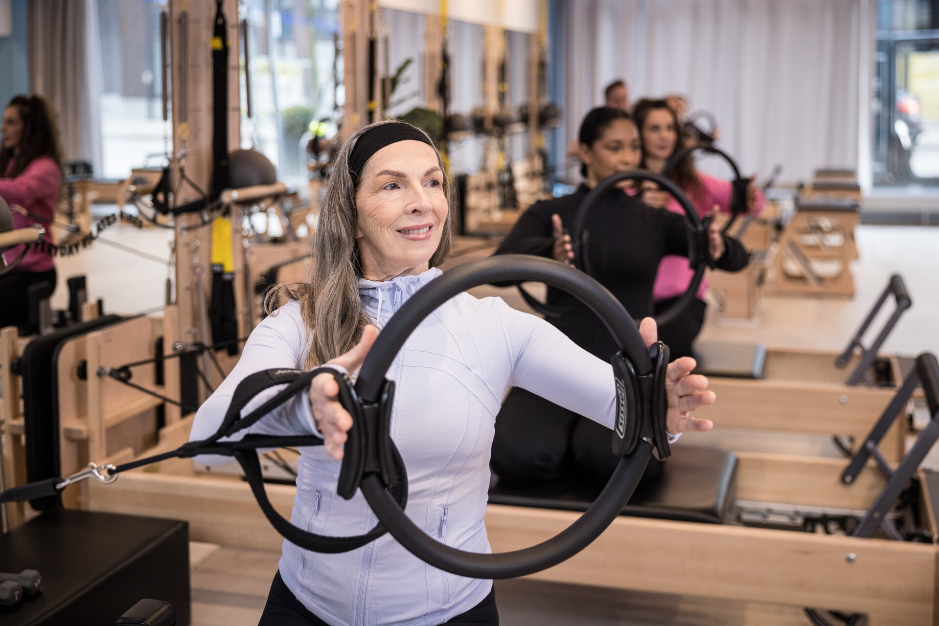 reformer pilates gruppenkurs: frau mit ring