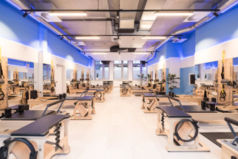 helles pilates studio mit holz reformern und spiegeln