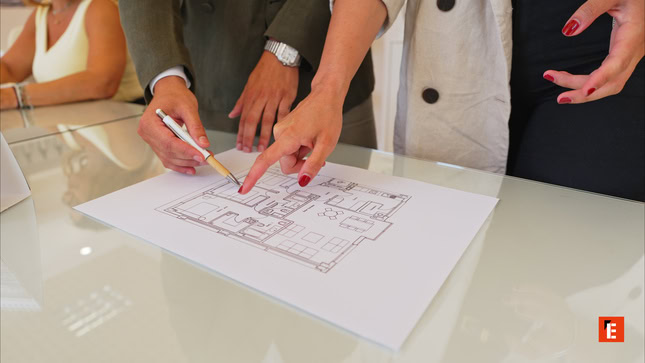 manos sobre plano de vivienda en reunión