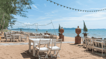 terraza de playa con mesas blancas y luces