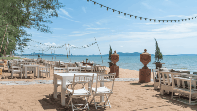 terraza de playa con mesas blancas y luces