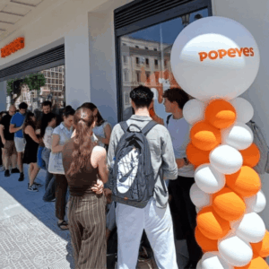 larga cola frente a popeyes con globos